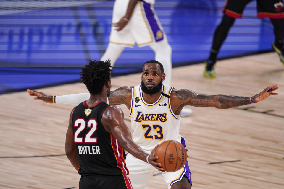 Los Angeles Lakers' LeBron James (23) attempt to block Miami Heat's Jimmy Butler (22) during the first half in Game 3 of basketball's NBA Finals, Sunday, Oct. 4, 2020, in Lake Buena Vista, Fla. (AP Photo/Mark J. Terrill)