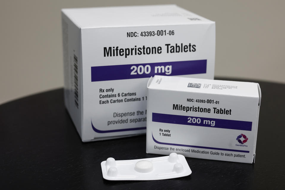 Packages of mifepristone tablets displayed on a table.