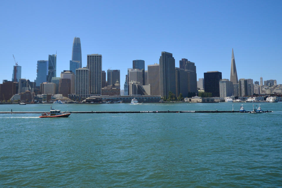 The Ocean Cleanup’s first buoyant trash-collecting device is seen in front of the San Francisco skyline en route to the Pacific Ocean on Saturday, Sept. 8, 2018. Once deployed, the boom will form a U-shaped barrier to trap plastic and trash that currently makes up the "Great Pacific Garbage Patch." (AP Photo/Lorin Eleni Gill)