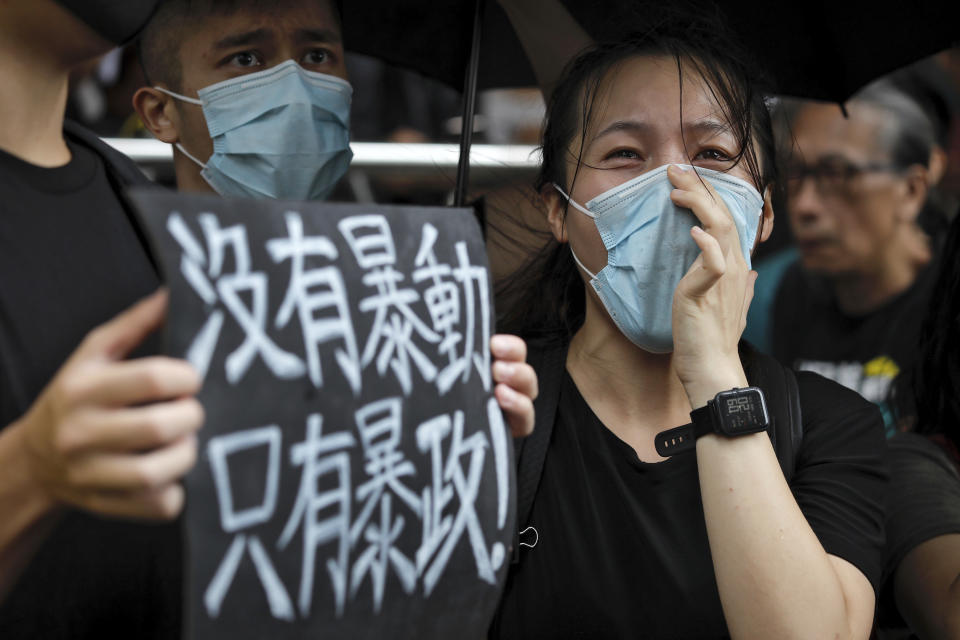 A protester holds a placard that reads: "No thug, only tyranny" as other chants slogans as they gather outside the Eastern Court in Hong Kong, Wednesday, July 31, 2019. Supporters rallied outside a court in Hong Kong on Wednesday ahead of a court appearance by more than 40 fellow protesters who have been charged with rioting. (AP Photo/Vincent Yu)