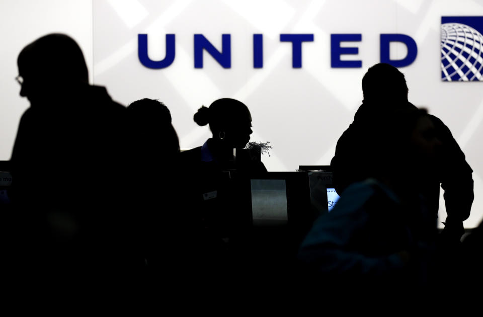 FILE - In this Saturday, Dec. 21, 2013, file photo, travelers check in at the United Airlines ticket counter at Terminal 1 in O'Hare International Airport in Chicago. United Airlines hopes to bring back supersonic travel before the end of this decade. United said Thursday, June 3, 2021 that it reached a deal with startup aircraft maker Boom Supersonic to buy 15 of Boom's Overture jets. (AP Photo/Nam Y. Huh, File)