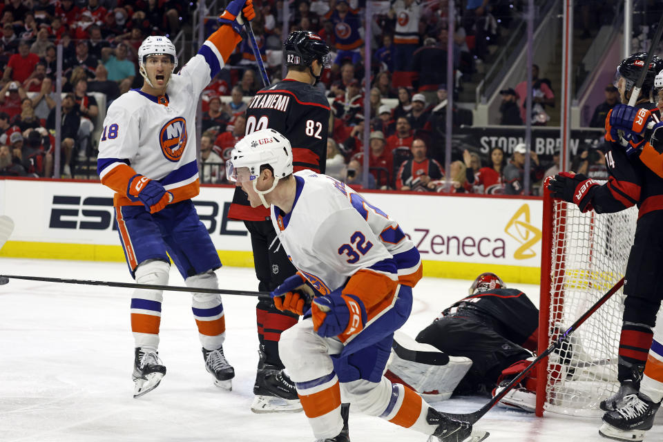 New York Islanders' Kyle MacLean (32) celebrates his goal with teammate Pierre Engvall (18) nearby during the first period in Game 1 of an NHL hockey Stanley Cup first-round playoff series against the Carolina Hurricanes in Raleigh, N.C., Saturday, April 20, 2024. (AP Photo/Karl B DeBlaker)