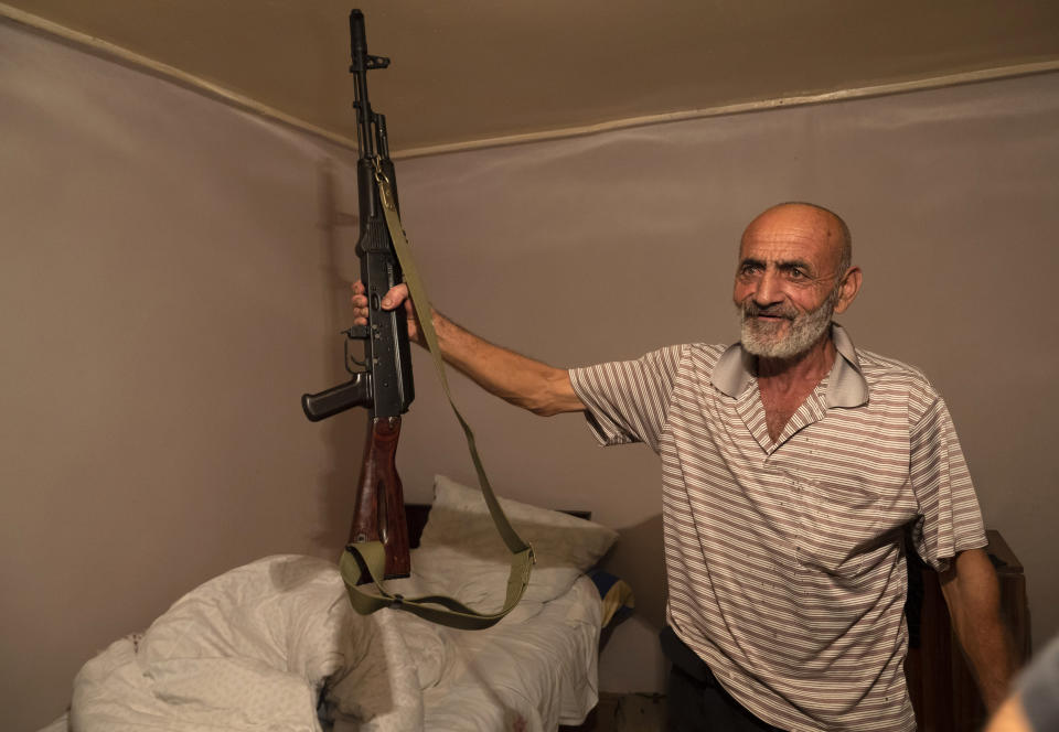 Local resident, Yury Ovanisyan holds a Kalashnikov guns that he received from a recruitment office in the town of Martuni, the separatist region of Nagorno-Karabakh, Wednesday, Oct. 14, 2020. The conflict between Armenia and Azerbaijan is escalating, with both sides exchanging accusations and claims of attacks over the separatist territory of Nagorno-Karabakh. Heavy fighting is in a third week despite a cease-fire deal. (AP Photo)