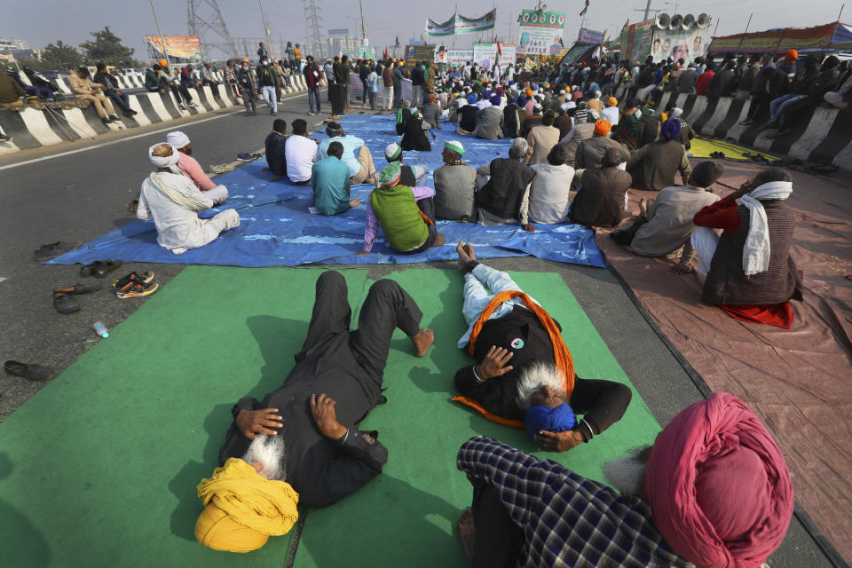 Indian farmers listen to a speaker as they block a highway in protest against new agricultural laws in New Delhi, India, on Dec. 21, 2020. India’s prime minister Narendra Modi Friday held virtual talks with farmers from six states and asked them to explain how the government’s agricultural policies have benefited them, a month after facing massive farmer protests that have rattled his administration. (AP Photo/Manish Swarup)