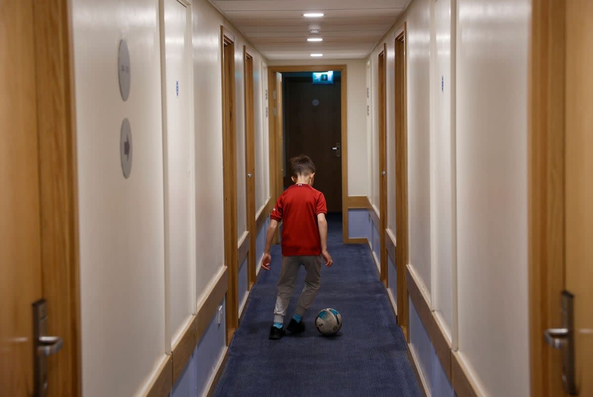 A boy plays football in the hallway of the Travelodge (Facundo Arrizabalaga)