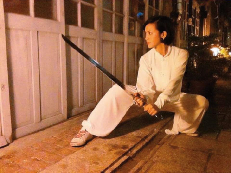 大約10年前，王瀞韓仍希望重拾武術夢。她專長南拳，圖為她身穿武術服、手持南刀。（王瀞韓提供）
