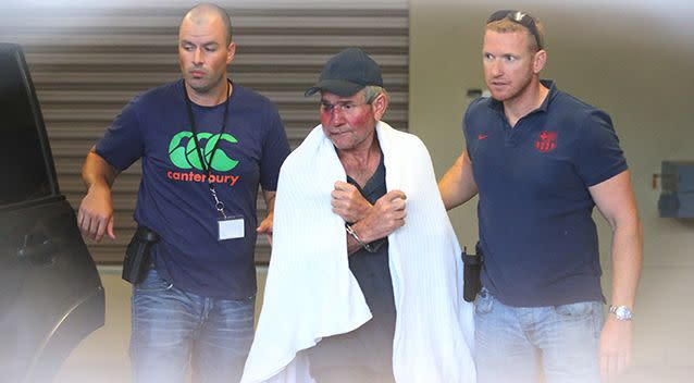 Gino Stocco is escorted by two policemen into Dubbo police station. Photo: AAP