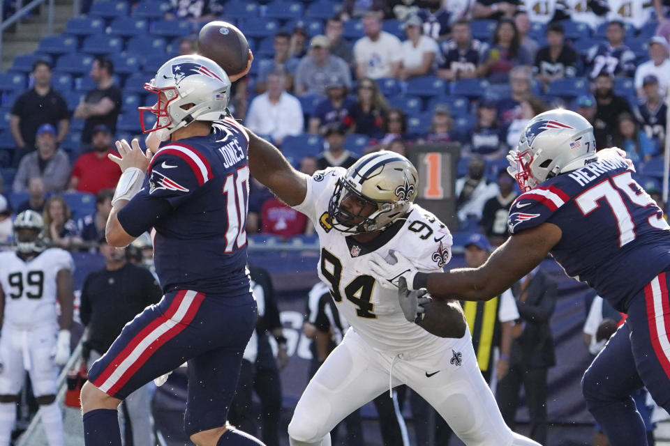 New England Patriots quarterback Mac Jones, left, passes while pressured by New Orleans Saints defensive end Cameron Jordan (94) during the second half of an NFL football game, Sunday, Sept. 26, 2021, in Foxborough, Mass. (AP Photo/Mary Schwalm)