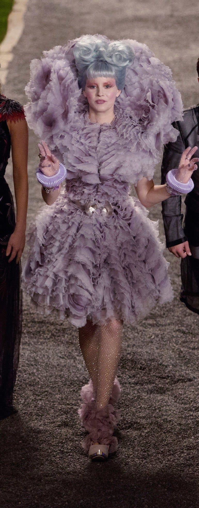 This is a beautiful costume, and while not all of the details work for me — sorry, wrist ruffs — it elevates Effie's normally dramatic wardrobe to new and even more bizarre heights. This is arguably her moment of greatest triumph in the film franchise, as the escort to not one but two Victors, and the literal height of her dress aligns with the figurative heights of her glee. 