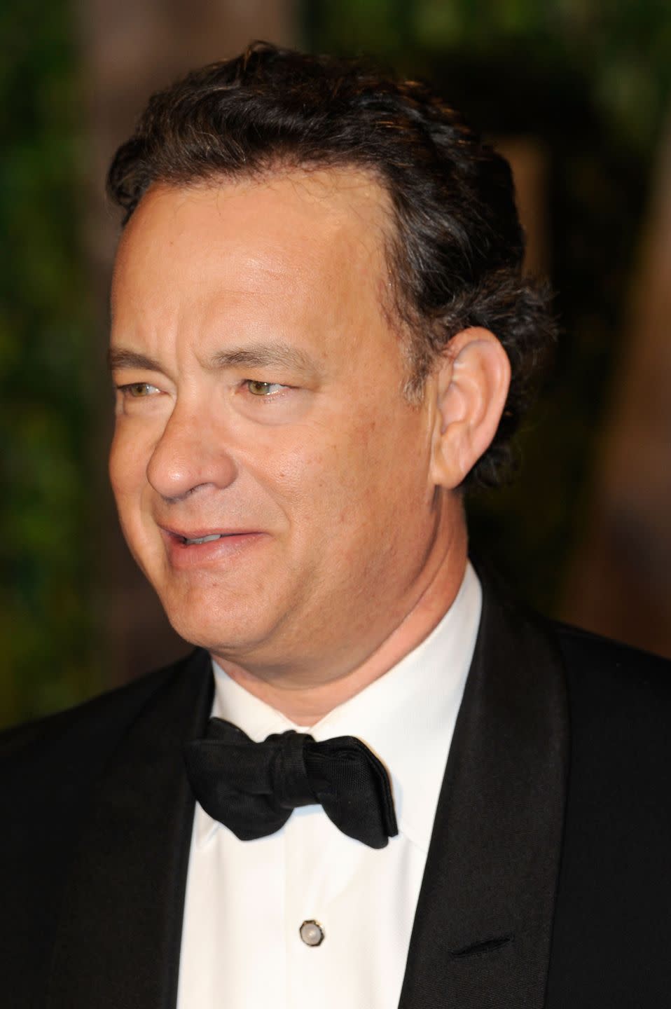 <p>Tom Hanks' natural brown curly hair is seen here as he arrives at the Vanity Fair Oscar Party in 2010. </p>