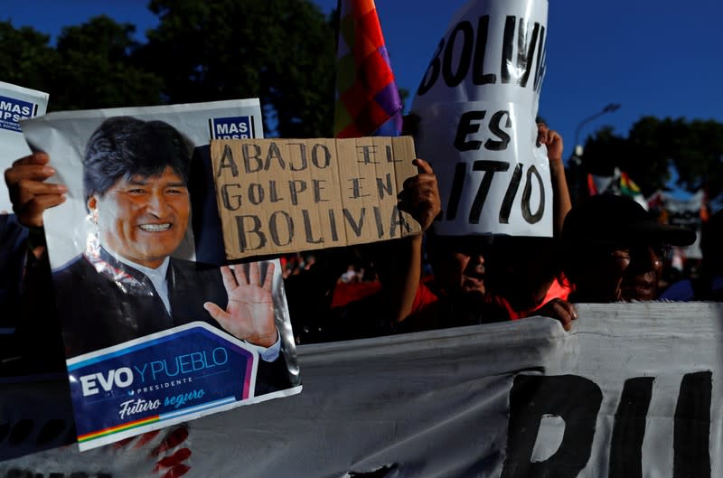 Seguidores del expresidente Evo Morales sostienen un cartel que dice "abajo el golpe en Bolivia" mientras se reunen fuera de la embajada de Bolivia en Buenos Aires para protestar contra el Gobierno, en Buenos Aires.