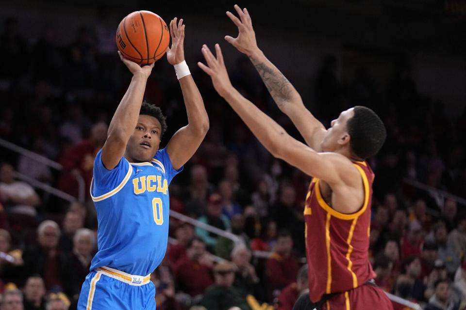 UCLA guard Jaylen Clark shoots as USC forward Kobe Johnson defends during the first half.