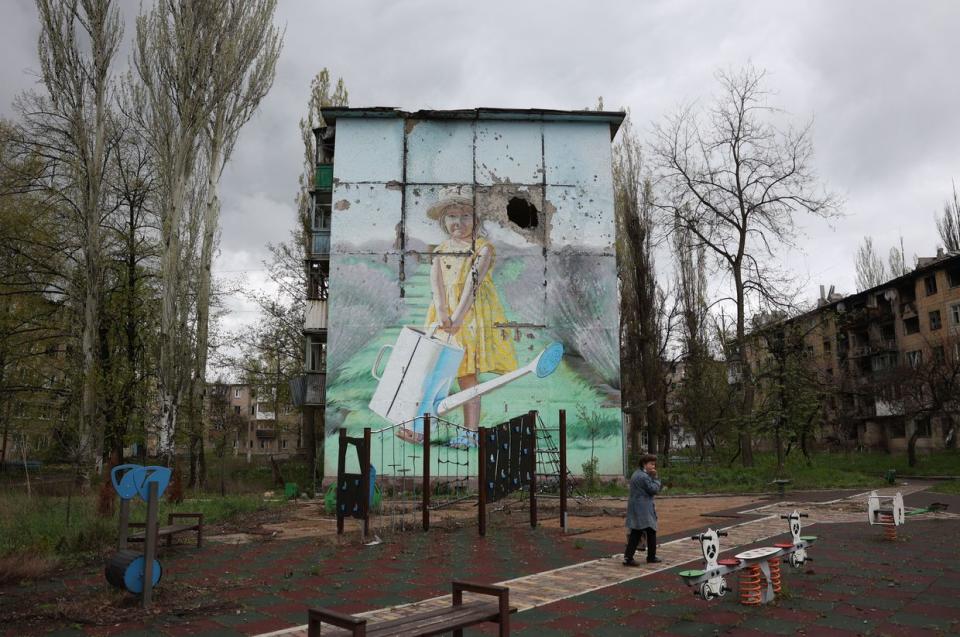 A local resident walks in front of a mural on a heavily damaged residential building in the frontline town of Avdiivka, Donetsk region on April 25, 2023, amid the Russian invasion of Ukraine. (Anatolii Stepanov / AFP via Getty Images)