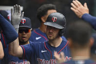 Minnesota Twins' Mitch Garver is congratulated in the dugout after hitting a solo home run off Cleveland Indians relief pitcher Sam Hentges in the fifth inning of a baseball game, Wednesday, April 28, 2021, in Cleveland. (AP Photo/David Dermer)
