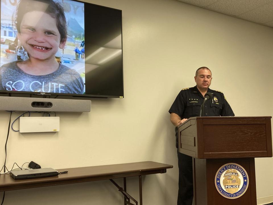 FILE - Honolulu Police Maj. Ben Moszkowicz addresses a news conference in Honolulu on Nov. 10, 2021, where law enforcement officers said they arrested the adopted parents of Isabella "Ariel" Kalua, shown on the screen. A Hawaii couple accused of killing their 6-year-old adoptive daughter a month before reporting her missing has pleaded not guilty to murder on Monday, Nov. 29, 2021. (AP Photo/Jennifer Sinco Kelleher, File)