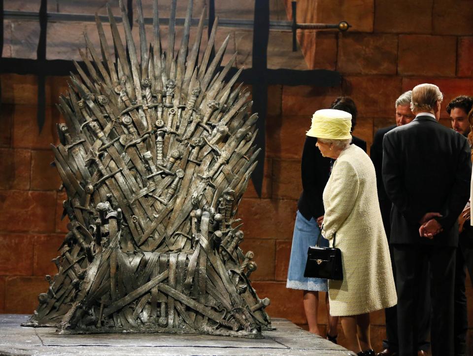 Britain's Queen Elizabeth looks at the Iron Throne as she meets cast members on the set of TV series Game of Thrones in Belfast