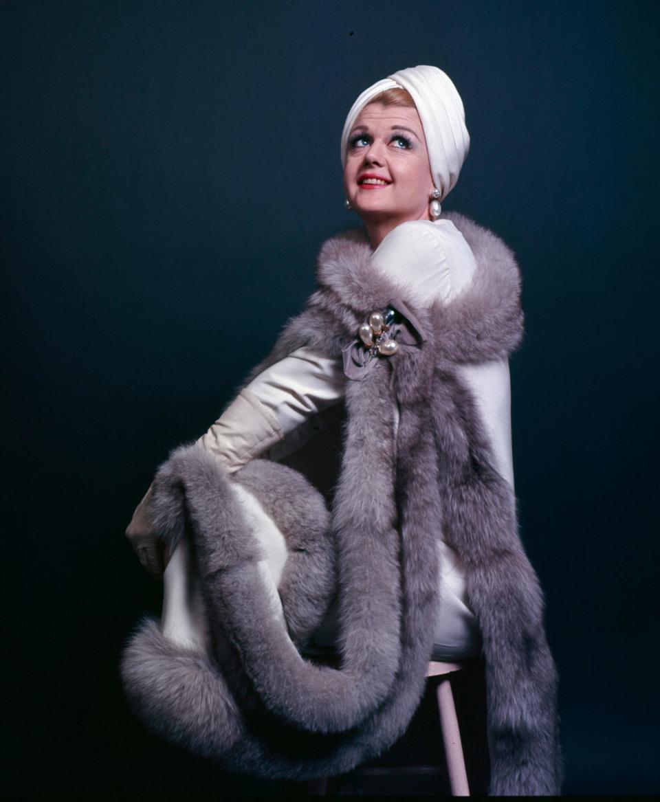 Angela Lansbury sitting on a stool