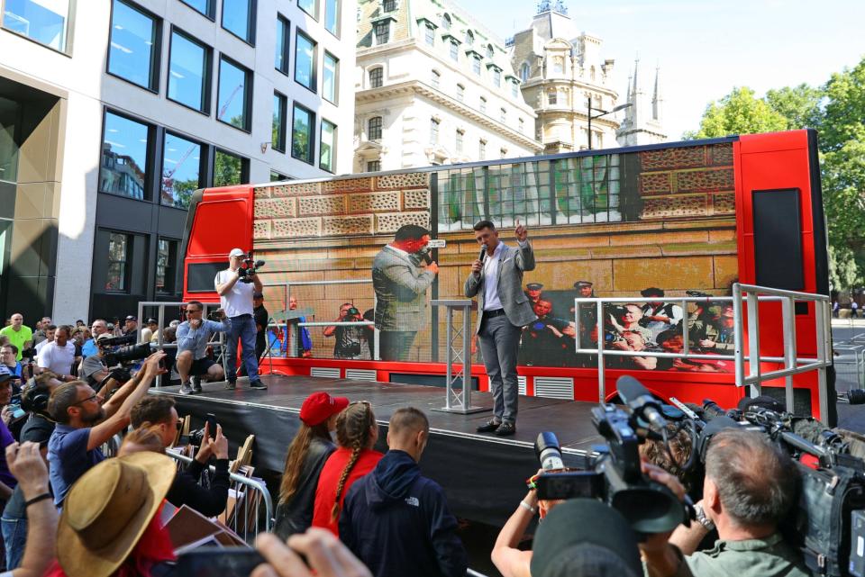 Robinson addresses supporters from the makeshift double-decker bus (PA)