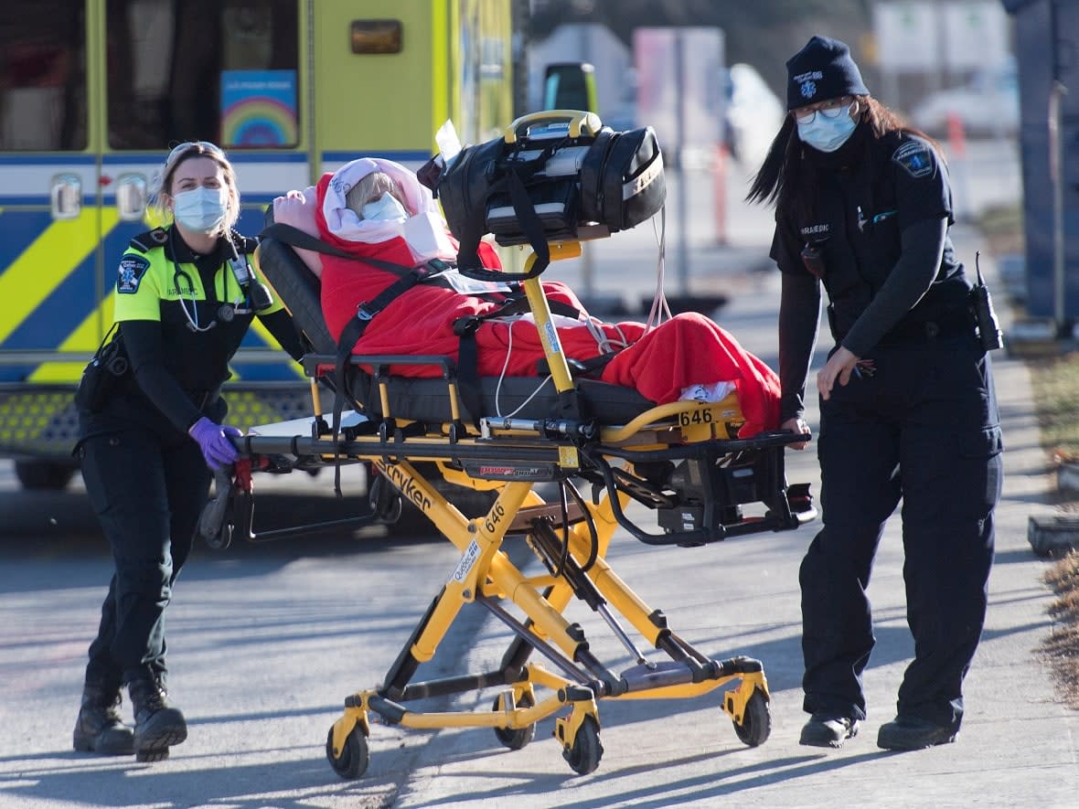 Paramedics transfer a person from an ambulance into a hospital in Montreal, Tuesday, December 29, 2020, at the height of the COVID-19 pandemic. (Graham Hughes/The Canadian Press - image credit)