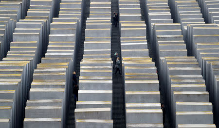 Visitors walk between the concrete elements of the Holocaust memorial as Germany marks the 80th anniversary of Kristallnacht, also known as Night of Broken Glass in Berlin, Germany November 9, 2018. REUTERS/Fabrizio Bensch