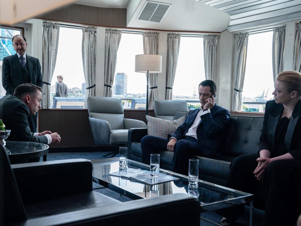 frank, roman, kendall, and shiv on succession, sitting in a small office room on a boat looking distraut