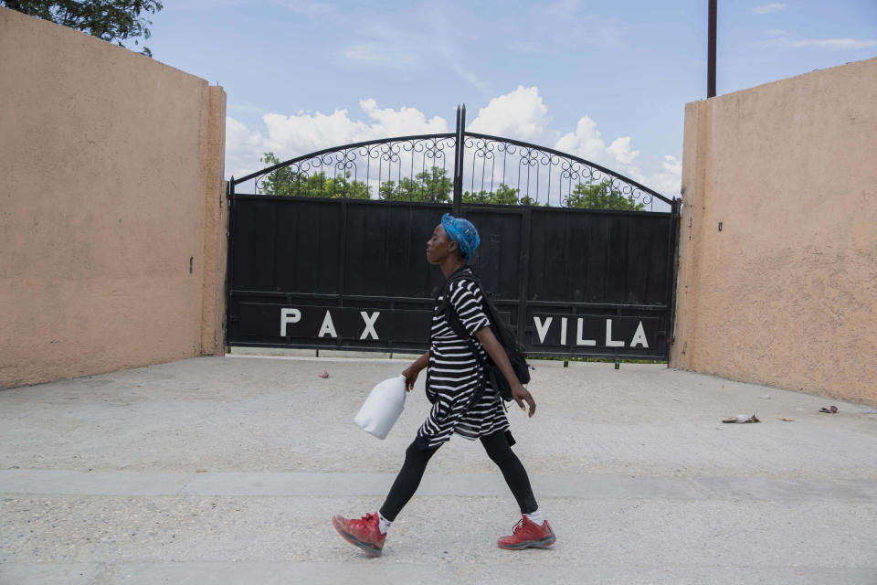 A woman walks past the entrance of the mortuary where the body of President Jovenel Moise was transferred to, in Port-au-Prince, Haiti, Saturday, July 10, 2021, three days after President Jovenel Moise was assassinated in his home . (AP Photo / Joseph Odelyn)