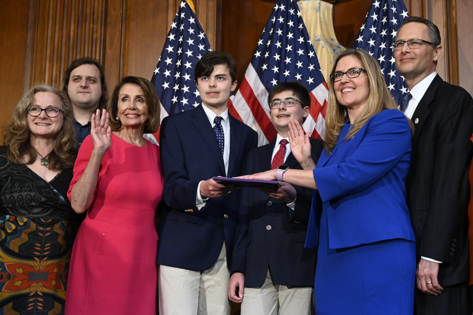 FILE - In this Thursday, Jan. 3, 2019 file photo, House Speaker Nancy Pelosi of Calif., third from left, poses during a ceremonial swearing-in with Rep. Jennifer Wexton, D-Va., second from right, on Capitol Hill in Washington, during the opening session of the 116th Congress. The newly elected Virginia congresswoman is displaying a transgender pride flag outside her Washington office. (AP Photo/Susan Walsh, File)