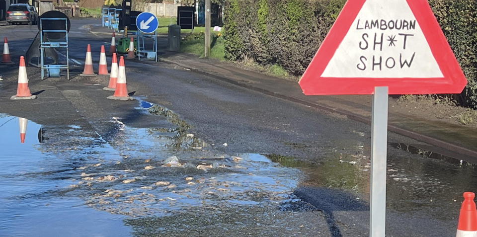 Angry locals fed up with sewage flooding the streets have erected a 's**t show' sign in Lambourn, Berkshire. (SWNS) 