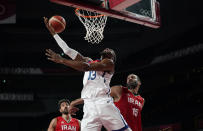 United States' Bam Adebayo (13), center, drives to the basket over Iran's Hamed Haddadi (15), right, during men's basketball preliminary round game at the 2020 Summer Olympics, Wednesday, July 28, 2021, in Saitama, Japan. (AP Photo/Charlie Neibergall)