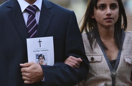 Jacintha Saldanha's widower Ben Barboza holds an order of service and the hand of his daughter Lisha (R) outside of Westminster Cathedral before a memorial service in London December 15, 2012. REUTERS/Toby Melville