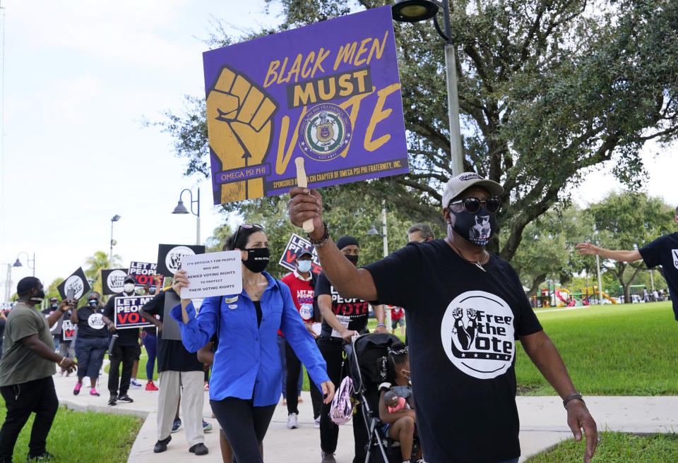 Supporters of restoring Florida felons' voting rights march to an early voting precinct, Saturday, Oct. 24, 2020, in Fort Lauderdale, Fla. The Florida Rights Restoration Coalition led marches to the polls in dozens of Florida counties. (AP Photo/Marta Lavandier)