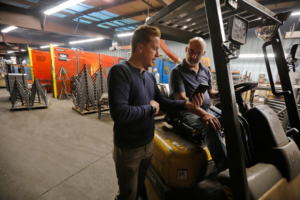 Brownell Boat Stands president Alex Kavanaugh speaks with Gary Dompierre, production manager, at the  manufacturing plant in the Mattapoisett industrial park.