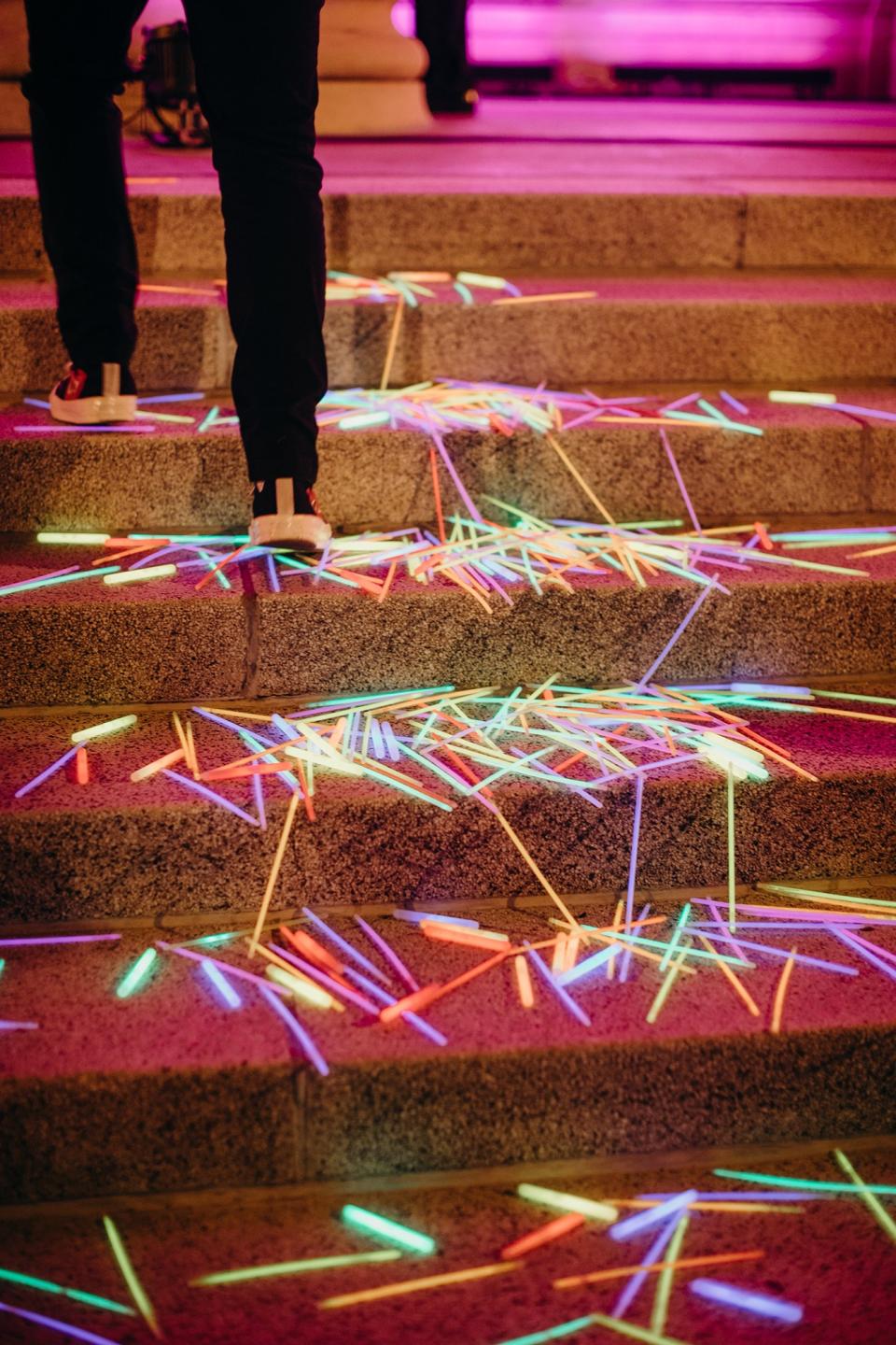 At around 10:00 p.m.—right at the moment when guests likely thought things were about to wind down—there was a dramatic light change, and buckets of glow sticks poured onto the steps of the museum, signaling it was time to move into the museum.