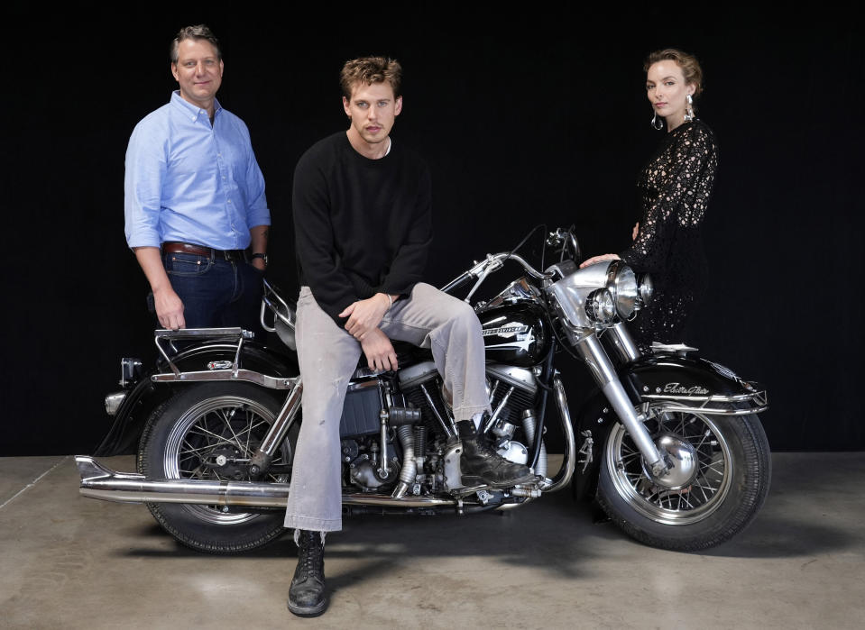 Jeff Nichols, izquierda, guionista y director de "The Bikeriders" posa con los miembros del elenco Austin Butler, centro, y Jodie Comer, el jueves 30 de mayo de 2024 en Los Angeles. La motocicleta es una Harley Davidson Pan Head 1965 que Butler montó en la película. (Foto AP/Chris Pizzello)