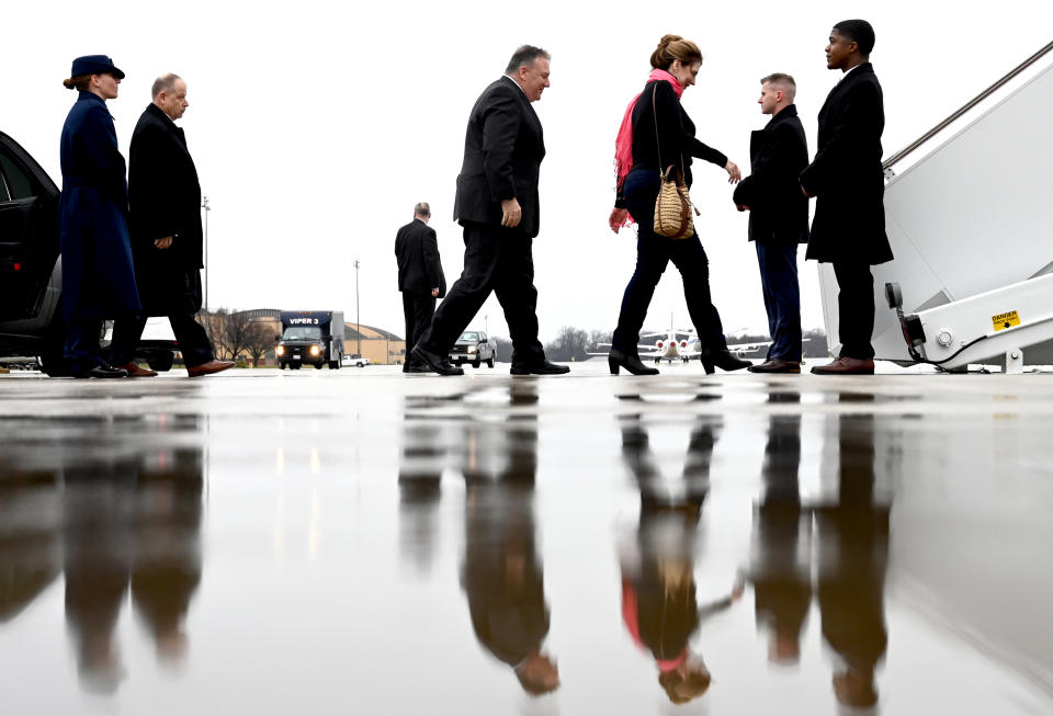 Secretary of State Mike Pompeo, center, walks with his wife Susan, to board a plane as he departs on a multi-country trip, Thursday, Feb. 13, 2020 at Andrews Air Force Base, Md. (Andrew Caballero-Reynolds/Pool via AP)