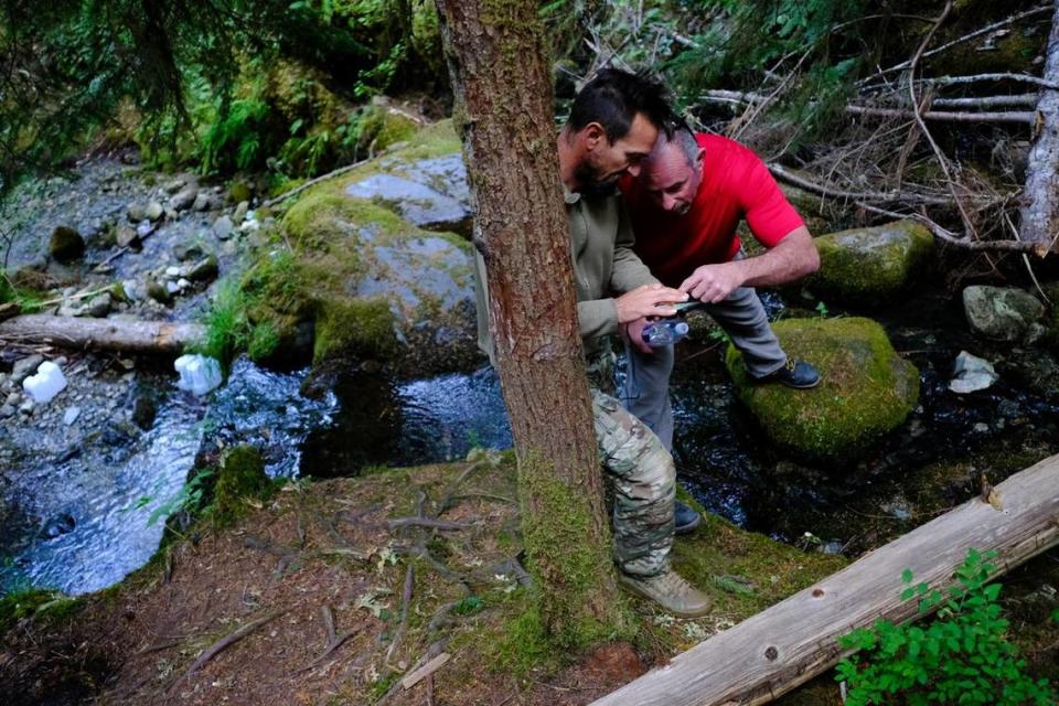 The day after finding Rachel Lakoduk, Bud Carr, left, shows Brad Tripp, Rachel’s father, where he found Rachel’s remains on his GPS on Sunday, Aug. 15, 2021, above the 49th Parallels’ base camp off of Cascade River Road near Marblemount, Wash.