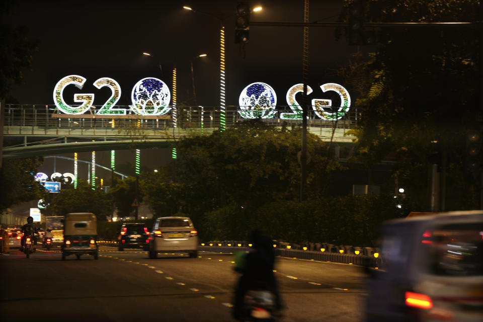 G20 logos are illuminated with the colors of the Indian flag on a pedestrian bridge in New Delhi, India, Aug. 27, 2023. Ahead of the summit, historical monuments, airports and major landmarks are projecting this year's G20 logo an image of a globe inside a lotus, using the colors of the Indian flag. The opposition says it is no coincidence that the lotus is also the election symbol of Modi's Bharatiya Janata Party. (AP Photo/Manish Swarup)