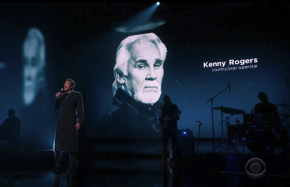 In this video grab provided by CBS and the Recording Academy, Lionel Richie performs during the In Memoriam as Kenny Rogers is pictured on screen at the 63rd annual Grammy Awards at the Los Angeles Convention Center on Sunday, March 14, 2021. (CBS/Recording Academy via AP)