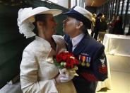 Retired U.S. Coast Guard Petty Officer 1st Class Nancy Monahan, right, wears her dress uniform as she leans to kiss her soon-to-be bride Deb Needham while they wait at Seattle City Hall to become among the first gay couples to legally wed in Washington state, Sunday, Dec. 9, 2012, in Seattle. The couple is from Renton, Wash. Gov. Chris Gregoire signed a voter-approved law legalizing gay marriage Dec. 5 and weddings for gay and lesbian couples began in Washington on Sunday, following the three-day waiting period after marriage licenses were issued earlier in the week. (AP Photo/Elaine Thompson)