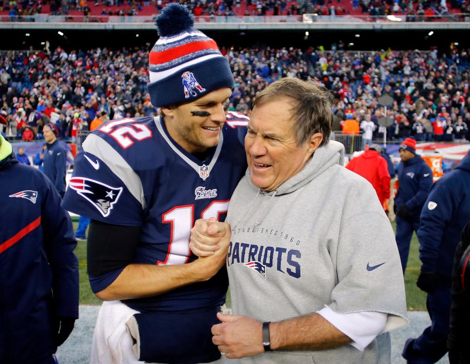 New England Patriots quarterback Tom Brady (12) celebrates with head coach Bill Belichick (R) after clinching the AFC East title with a 41-13 win over the Miami Dolphins at Gillette Stadium.