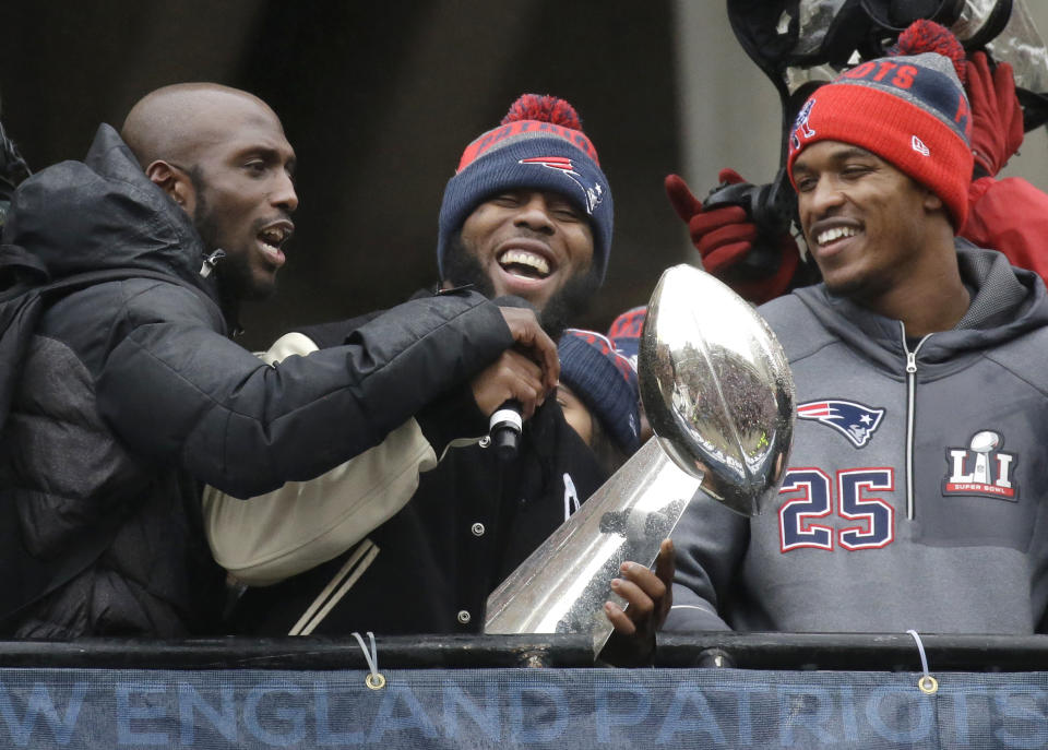 FILE - New England Patriots safety Devin McCourty, left, running back James White, center, and defensive back Eric Rowe (25) laugh with a Super Bowl trophy during a rally Tuesday, Feb. 7, 2017, in Boston, to celebrate Sunday's 34-28 win over the Atlanta Falcons in the NFL Super Bowl 51 football game in Houston. James White said Thursday, Aug. 11, 2022, he is retiring from the NFL. (AP Photo/Elise Amendola, File)