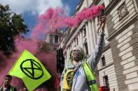 An activist from the climate protest group Extinction Rebellion holds up a smoke canister as a group of protesters targets Parliament Square in London on September 1, 2020, at the start of their new season of "mass rebellions". - Climate protest group Extinction Rebellion will target Britain's parliament as part of "mass rebellions" starting from September 1. Other actions will take place around the country. (Photo by ISABEL INFANTES / AFP) (Photo by ISABEL INFANTES/AFP via Getty Images)