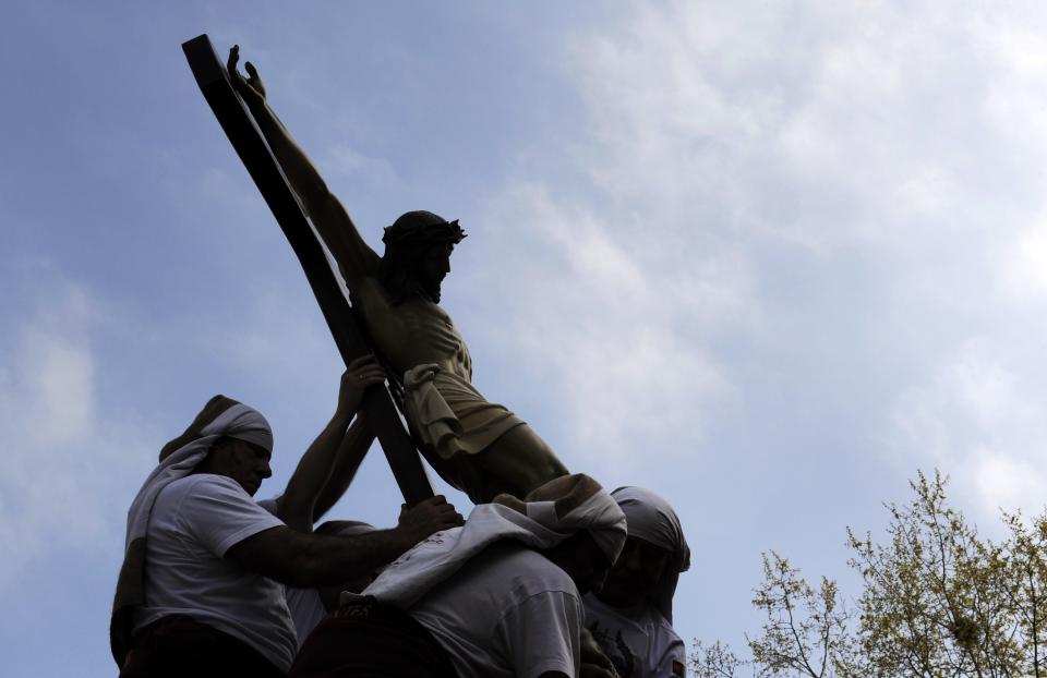 Penitents place a statue of Jesus Christ on top of a float during the Palm Sunday procession of the "Estudiantes" brotherhood in Oviedo