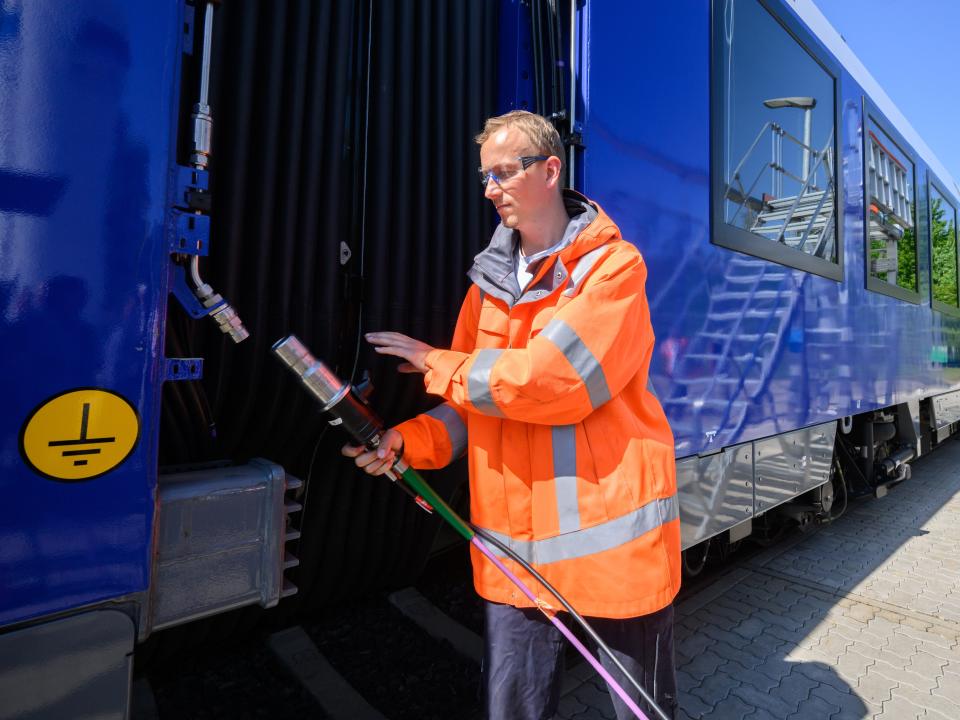 Employees refuel a hydrogen train