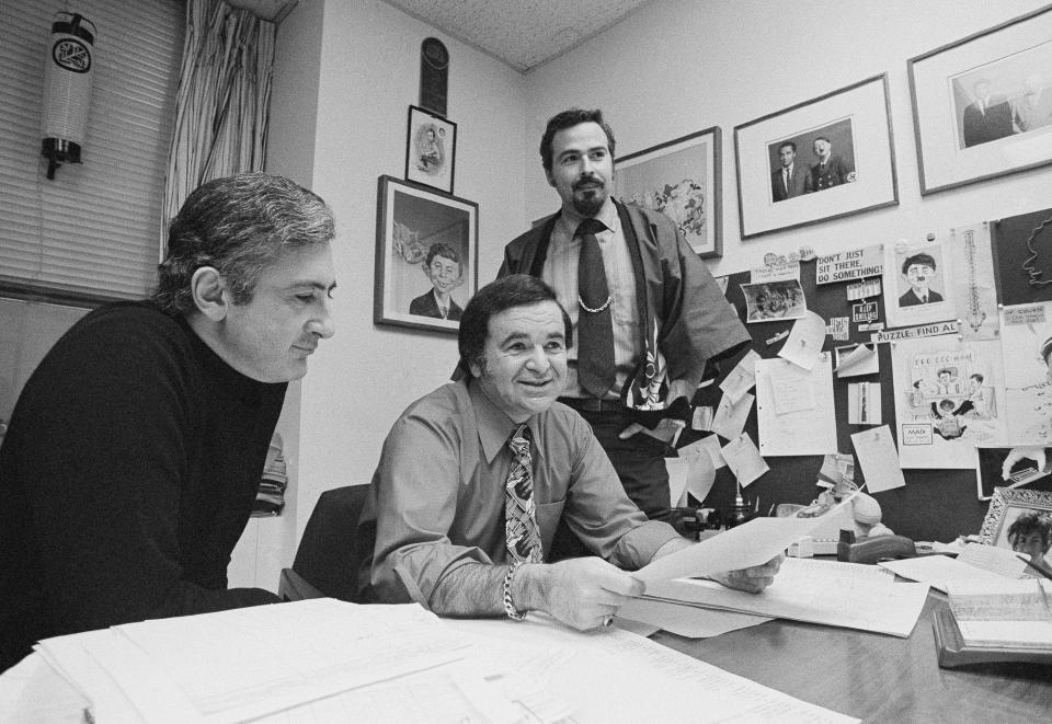 FILE - In this 1972 file photo, "Mad" magazine Editor Al Feldstein, center, sits with Art Director John Putnam, left, and a freelancer named Jack, at the magazine's New York headquarters. Feldstein, whose 28 years at the helm of Mad transformed the satirical magazine into a pop culture institution, died Tuesday, April 29, 2014. He was 88. (AP Photo/Jerry Mosey, File)