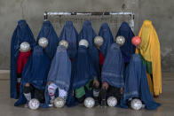 An Afghan women's soccer team poses for a photo in Kabul, Afghanistan, Thursday, Sept. 22, 2022. The ruling Taliban have banned women from sports as well as barring them from most schooling and many realms of work. A number of women posed for an AP photographer for portraits with the equipment of the sports they loved. Though they do not necessarily wear the burqa in regular life, they chose to hide their identities with their burqas because they fear Taliban reprisals and because some of them continue to practice their sports in secret. (AP Photo/Ebrahim Noroozi)