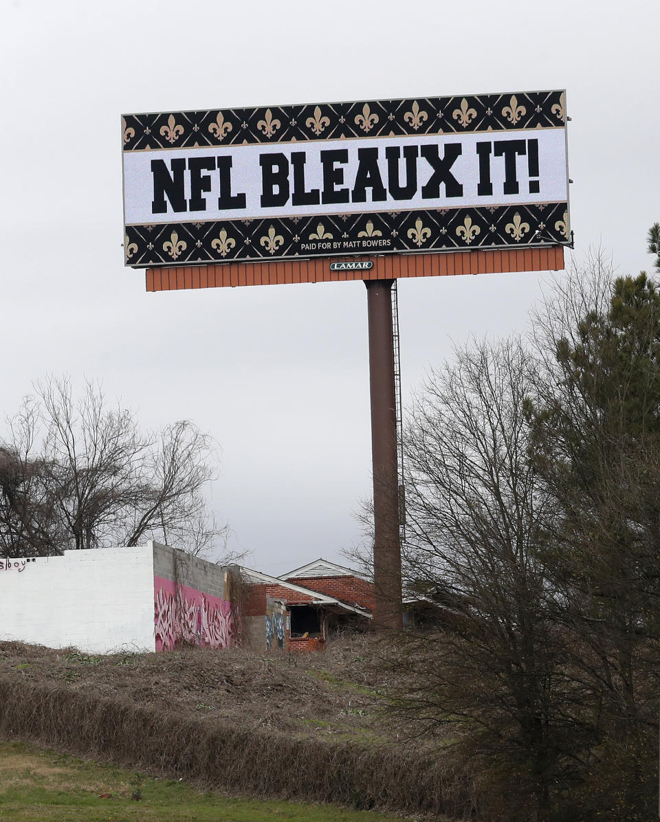 A billboard protesting a controversial call in the Sunday's NFL football game between the New Orleans Saints and Los Angeles Rams is shown along Interstate 75 near Hartsfield Jackson Atlanta International Airport in Atlanta Tuesday, Jan. 22, 2019. The Los Angeles Rams and New England Patriots will be welcomed to Atlanta for the Super Bowl by several billboards saying "Saints got robbed" and "NFL bleaux it." WDSU-TV reports Louisiana car dealership owner Matt Bowers paid for 10 billboards across Atlanta through Feb. 3. (AP Photo/John Bazemore)