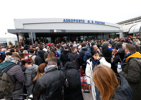 Passengers who were evacuated due to a fire at Ciampino Airport in Rome, Italy, February 19, 2019 gather outside the teminal building. REUTERS/Yara Nardi