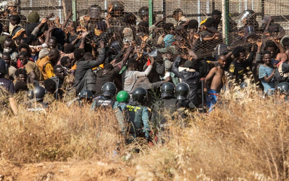 The fence is broken open with a bolt cutter allowing people to pass through - Javier Bernardo/AP