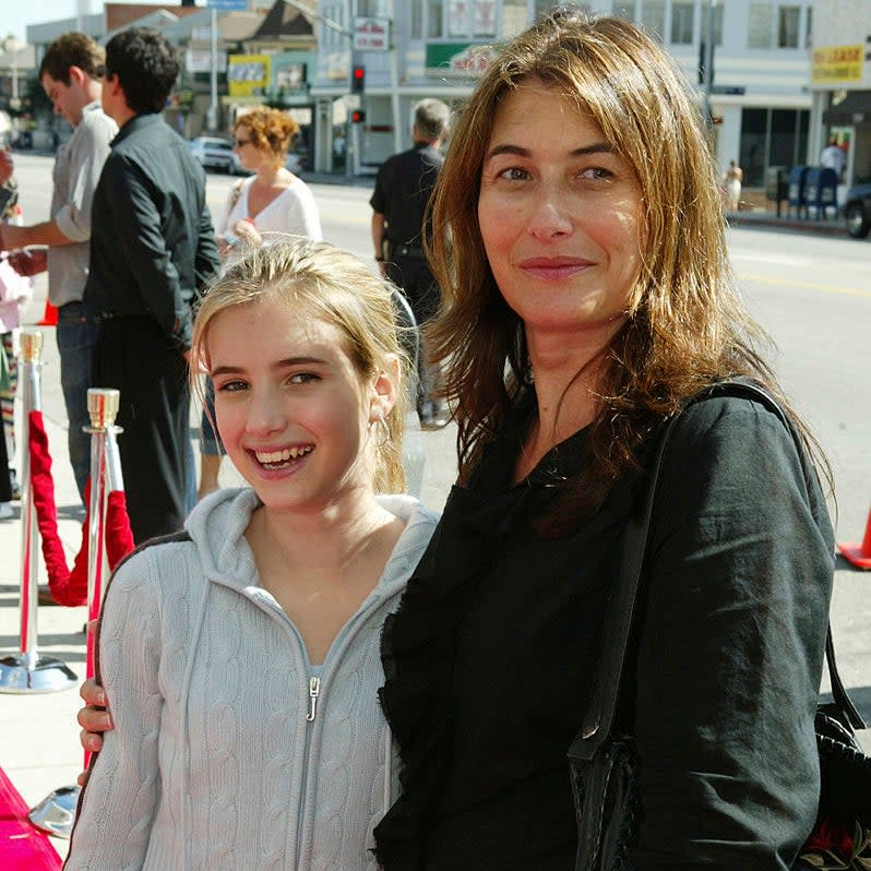 Emma as a kid with her mom in casual attire pose together at an event